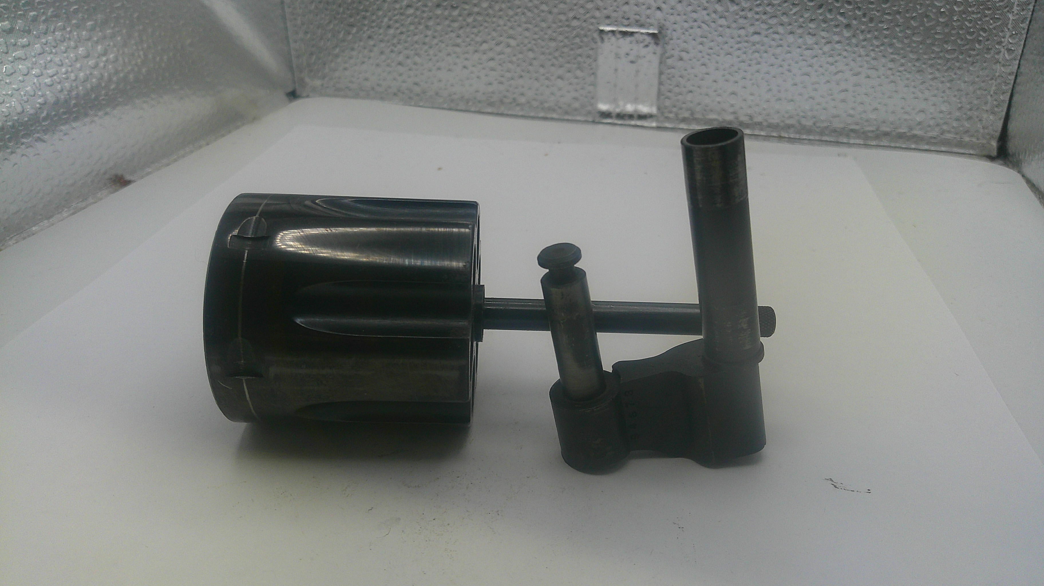 Black mechanical component on a white surface with a metallic background