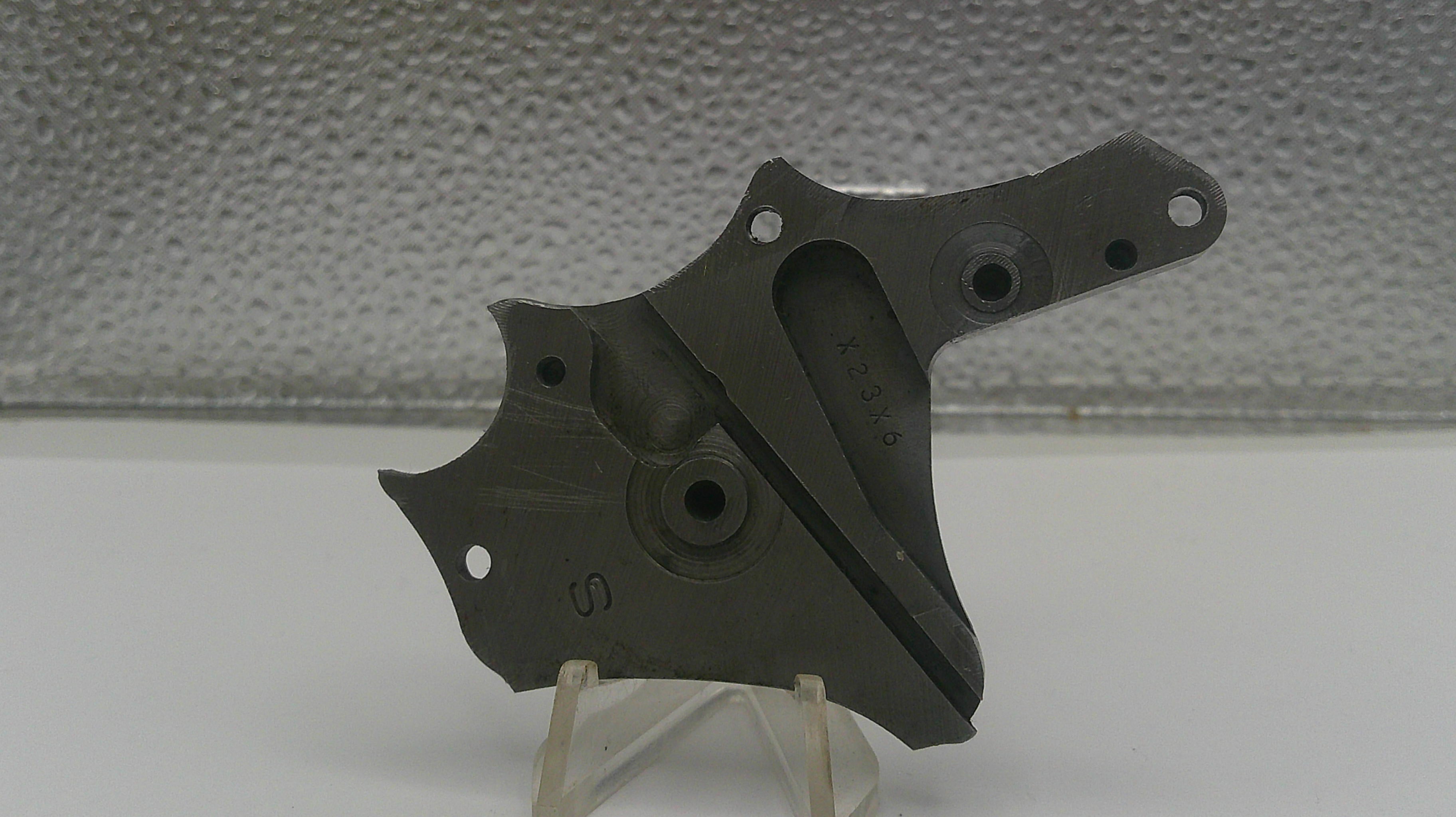 Black metal bracket on a stand against a textured gray background