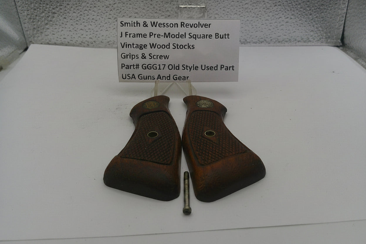 Smith & Wesson revolver grips and screw on a white surface with a label.