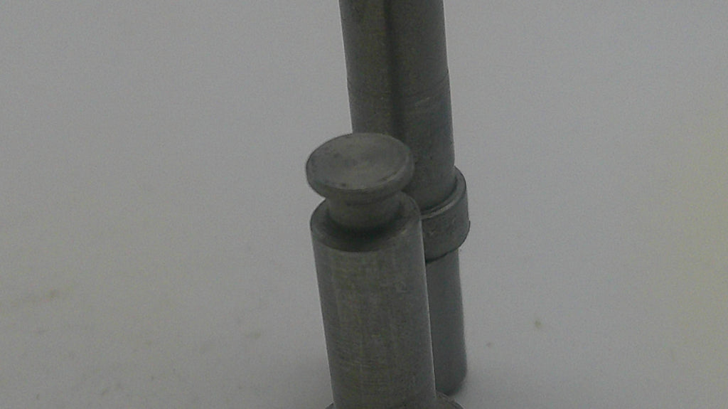 Metallic cylindrical object on a light gray background