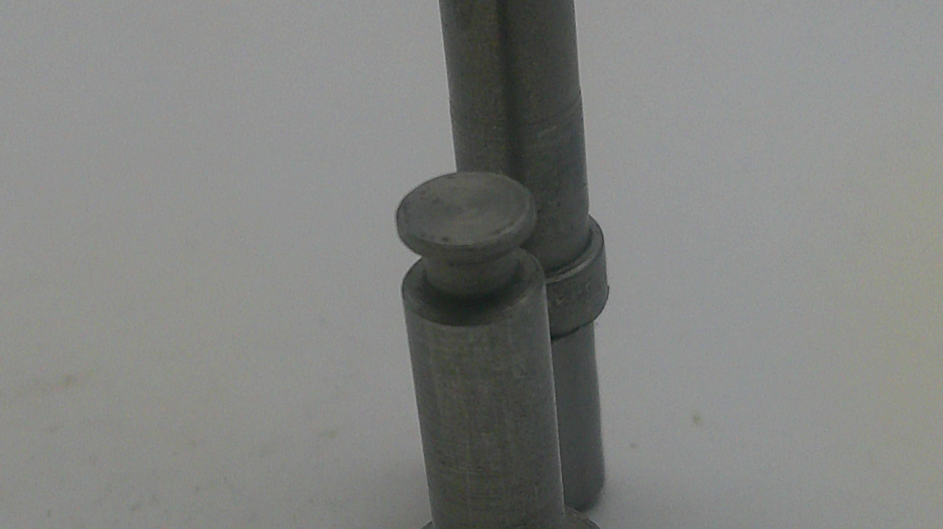 Metallic cylindrical object on a light gray background