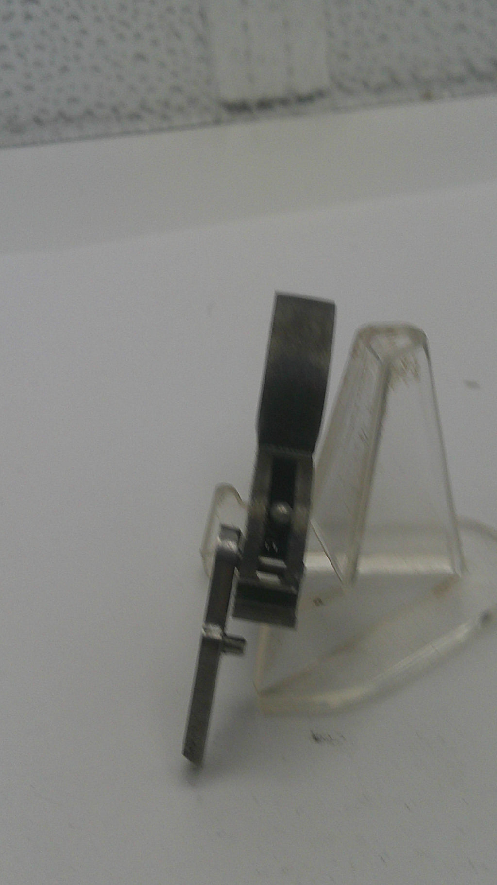 Metallic bracket attached to a white wall