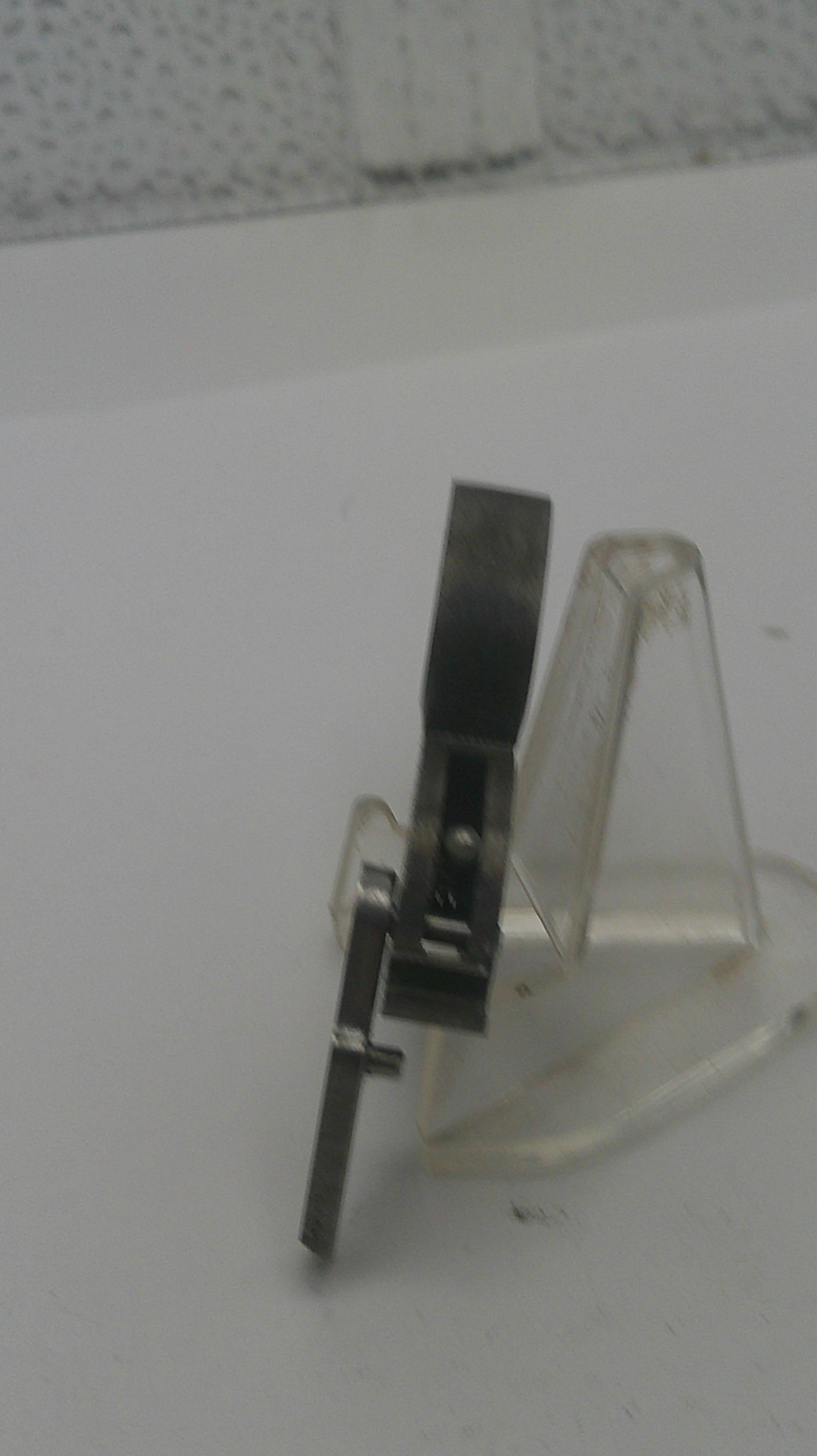 Metallic bracket attached to a white wall