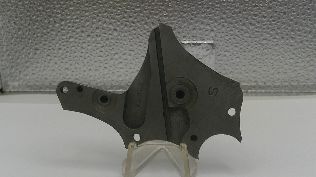 Black metal component on a stand with a textured gray background