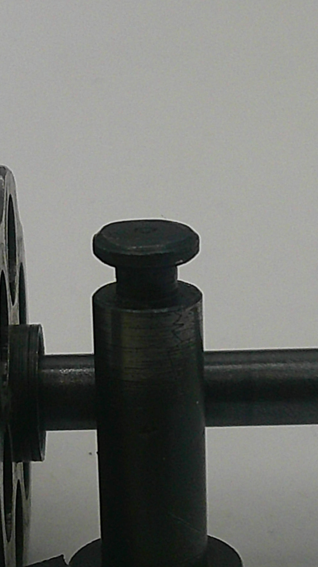 Close-up of a black metal component on a white background
