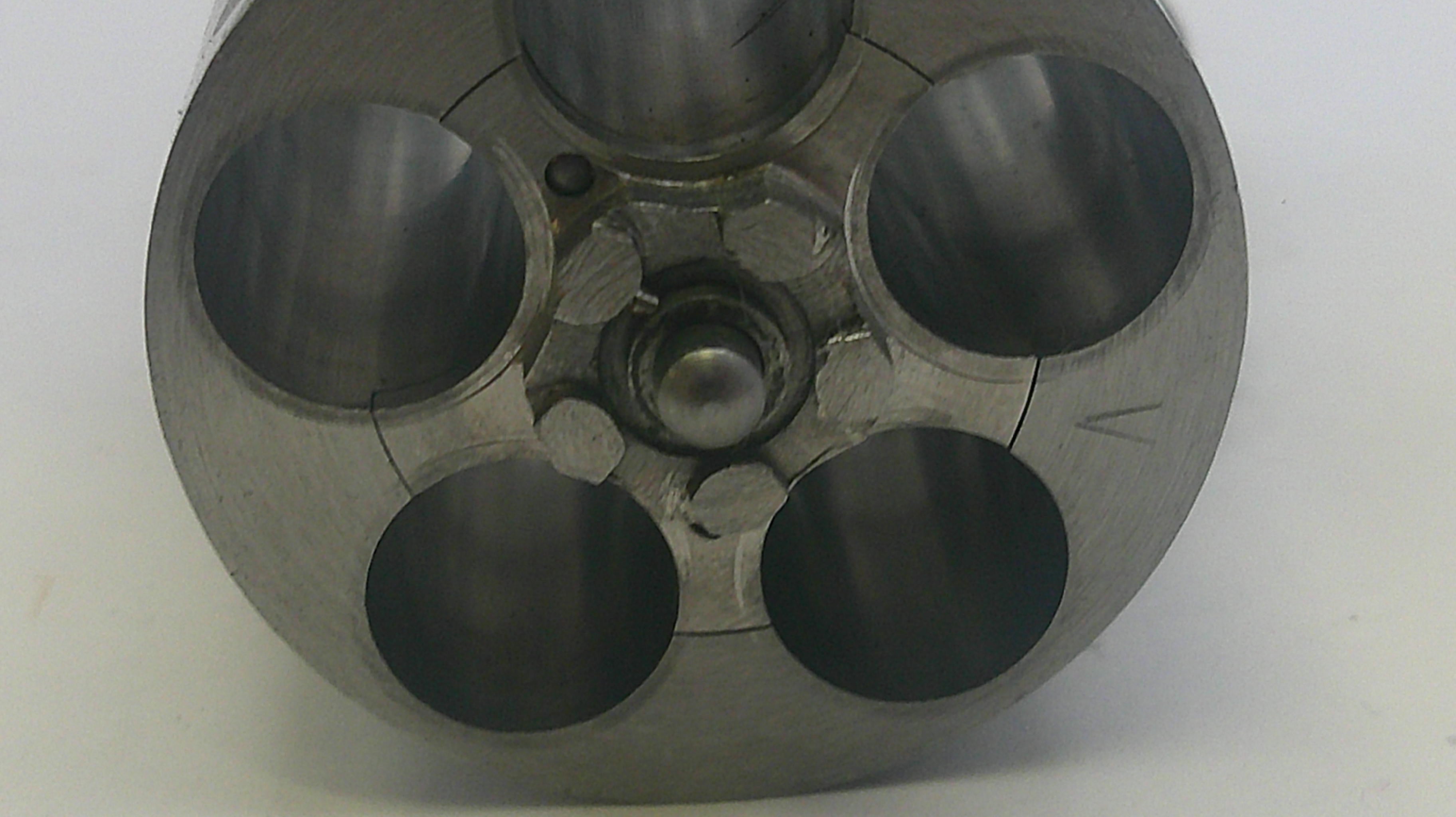 Metallic cylindrical component with multiple holes on a white background