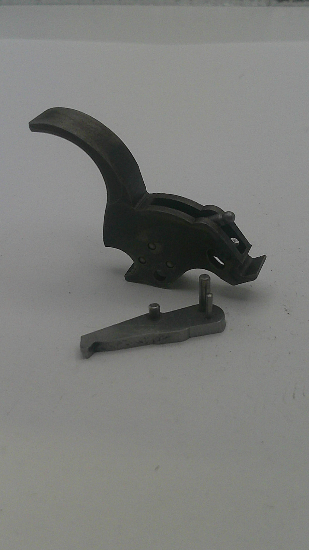 Black metal gun trigger on a white background