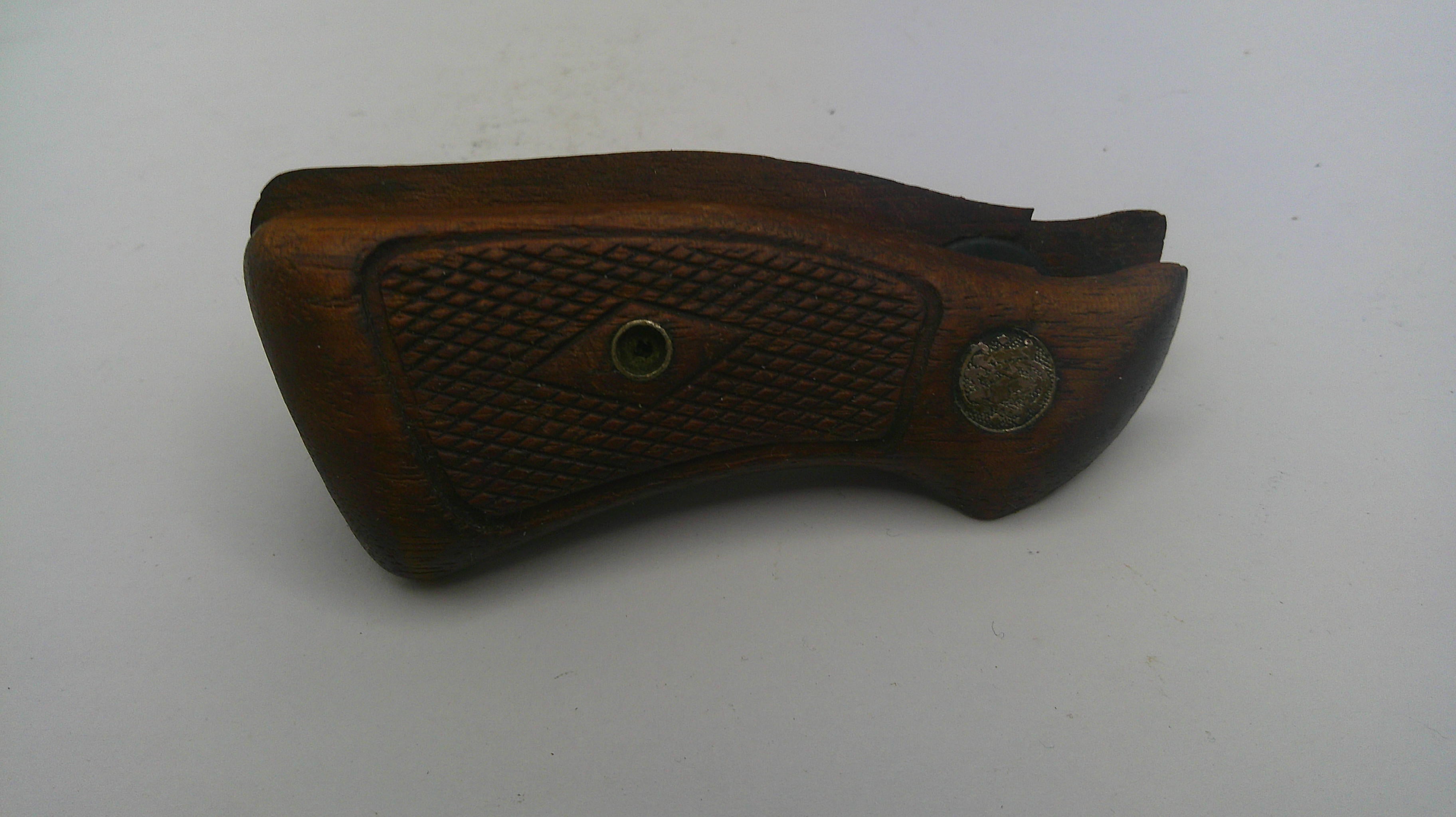 Wooden gun grip with textured surface on a white background