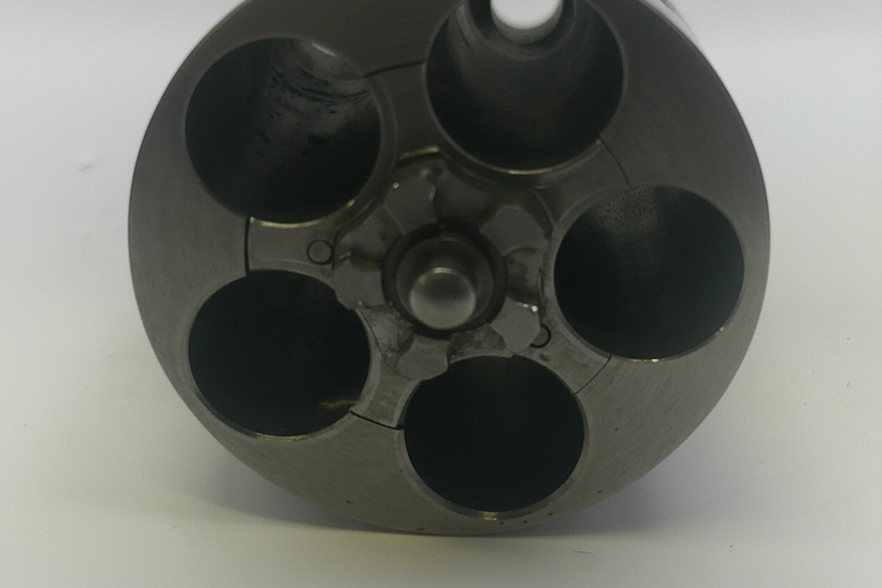 Close-up of a black cylindrical object with multiple holes on a white background