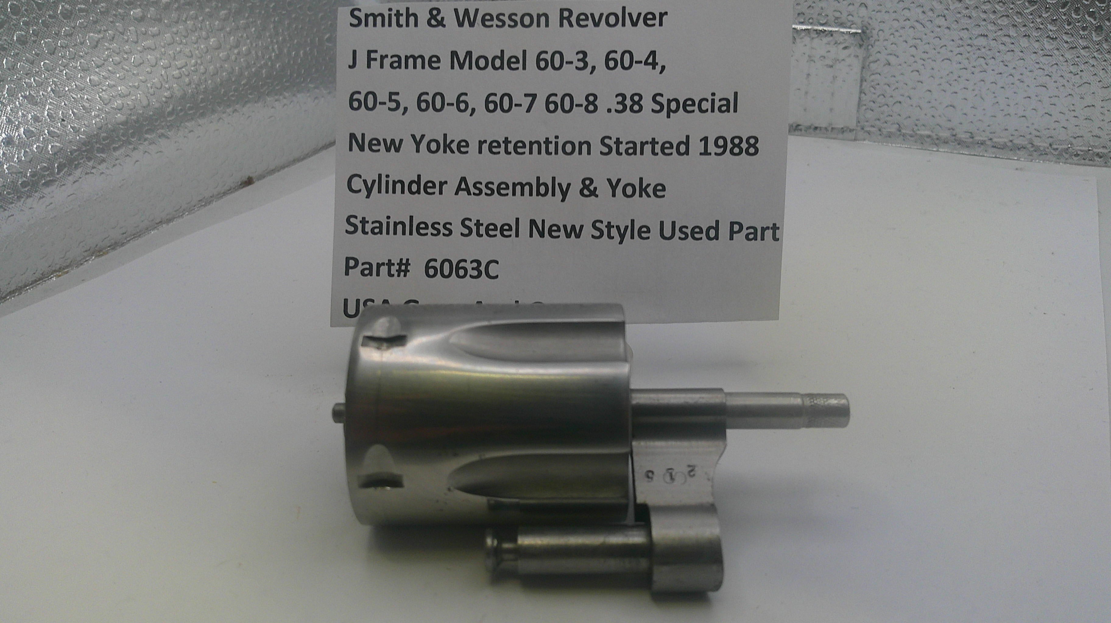 Smith & Wesson revolver cylinder assembly on a white surface with a descriptive card.
