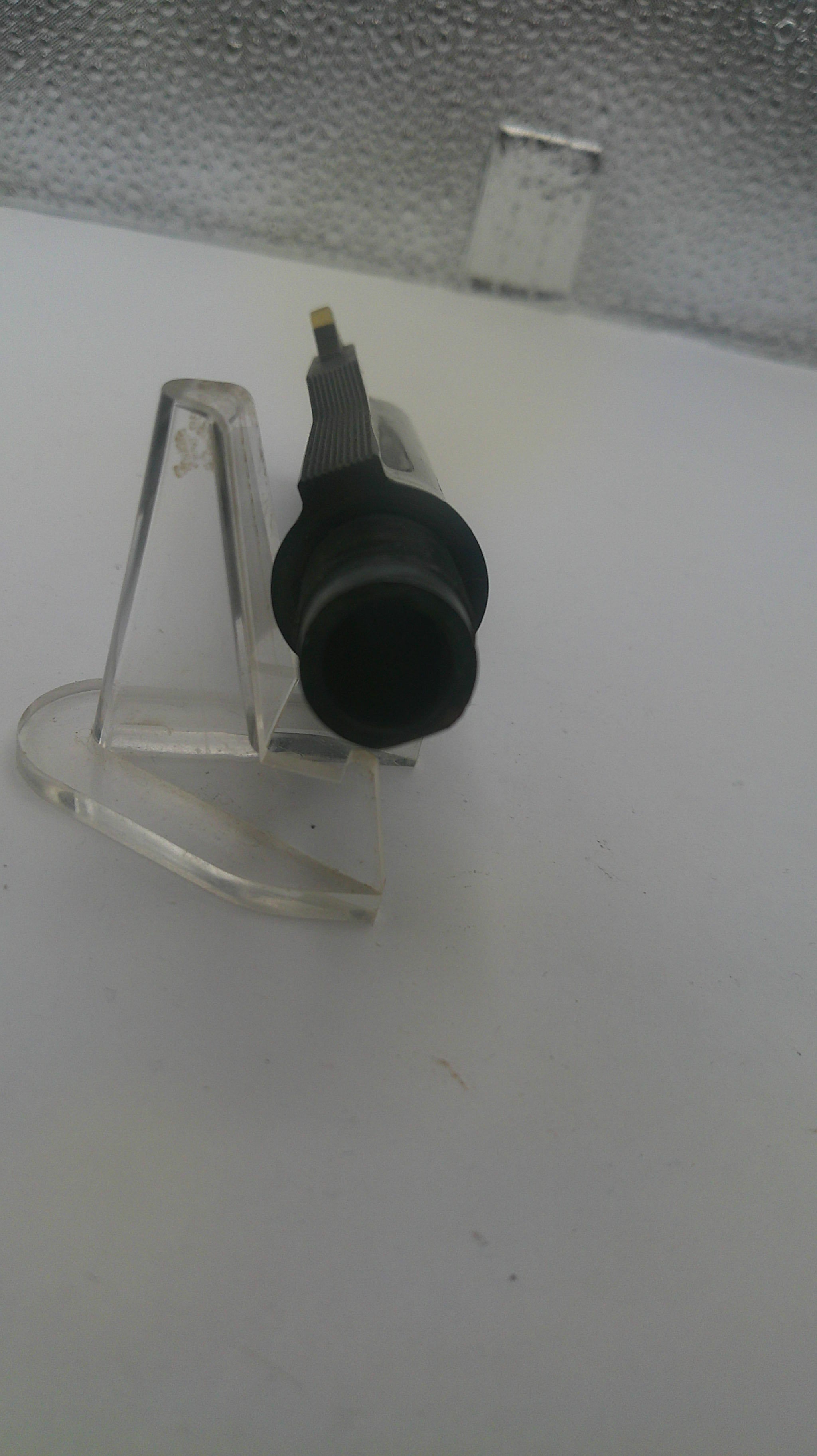 Black nozzle attached to a clear plastic holder on a white background