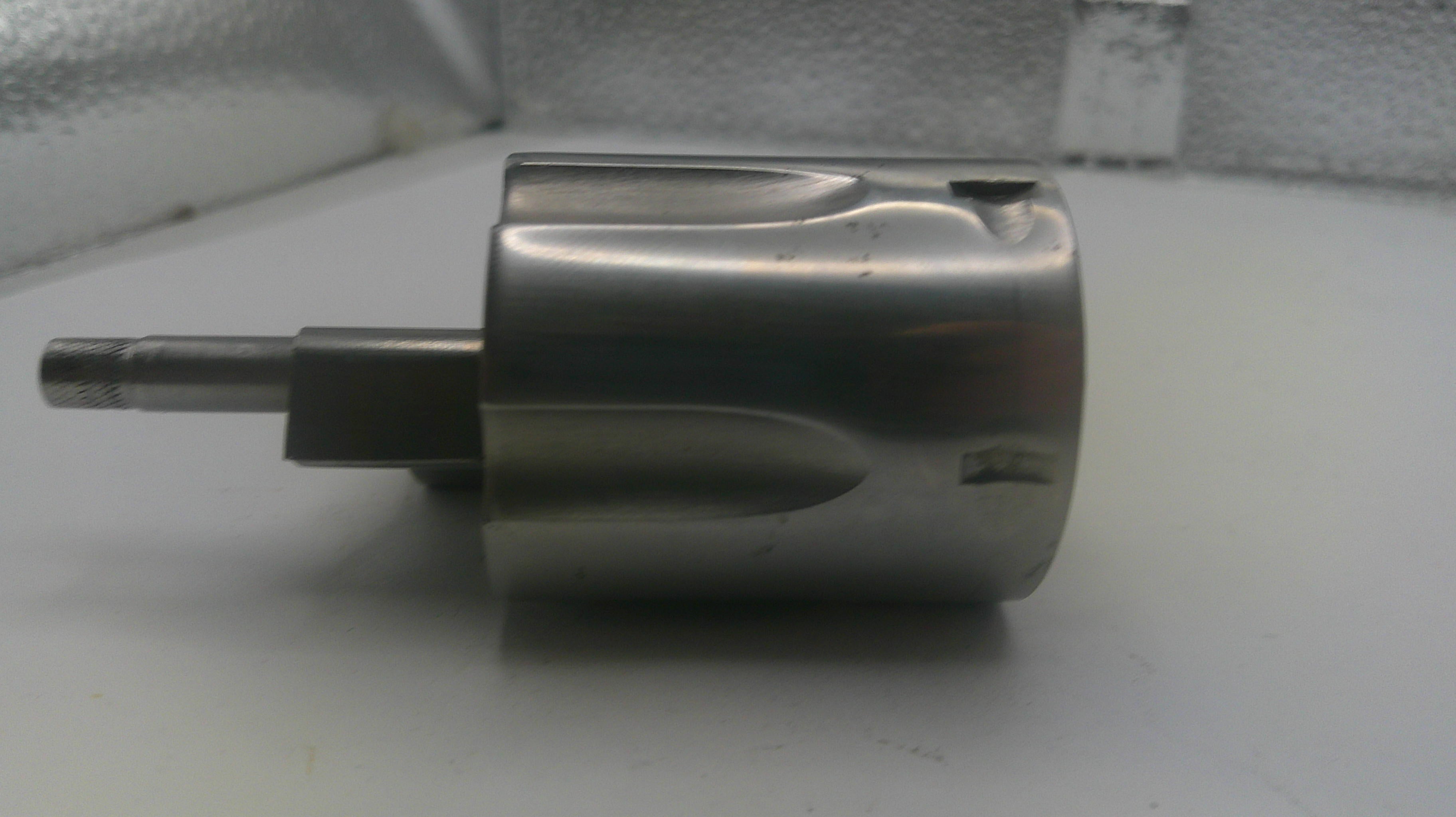 Metal component on a white surface with a neutral background