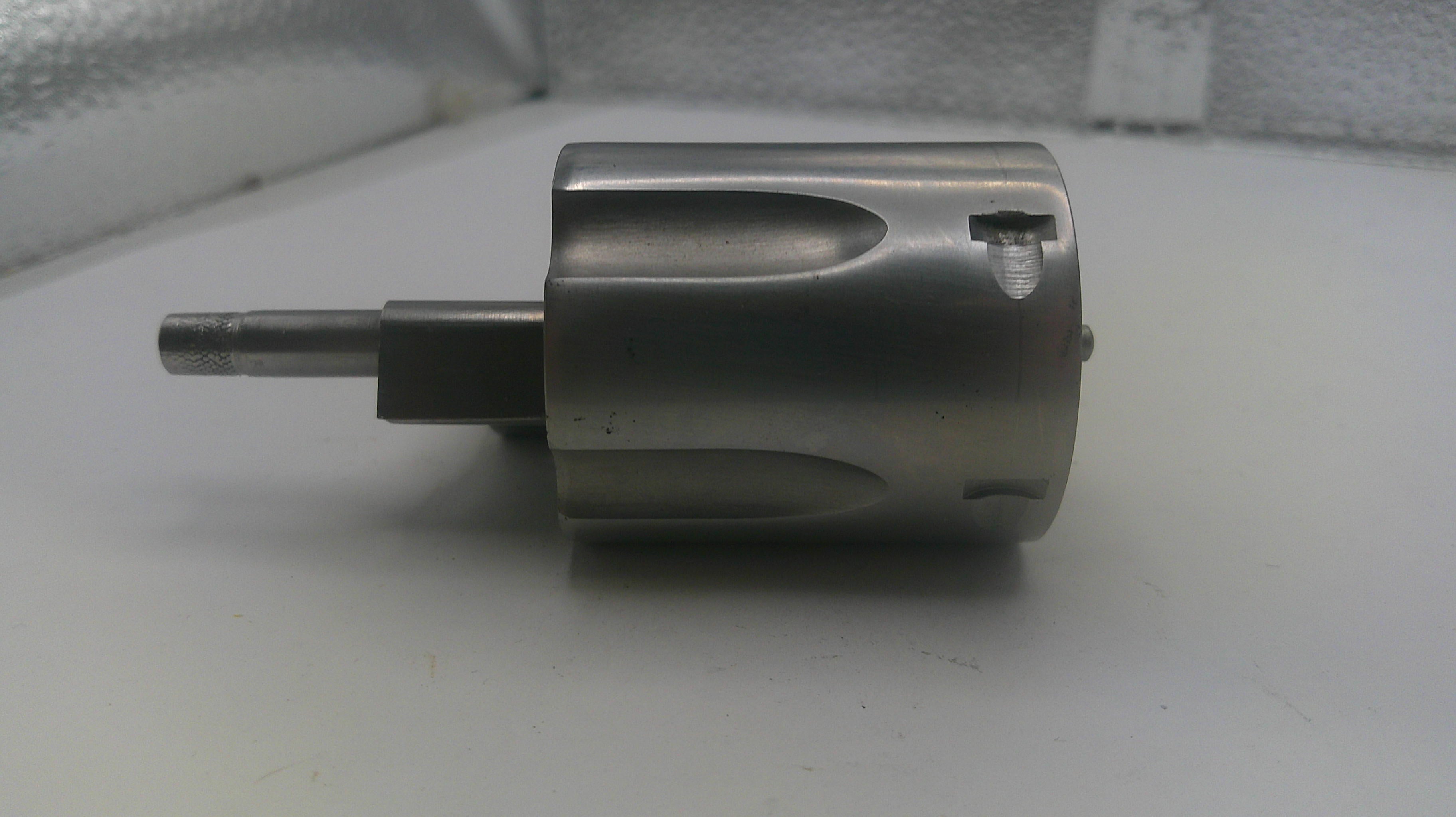 Metallic cylindrical component on a white surface