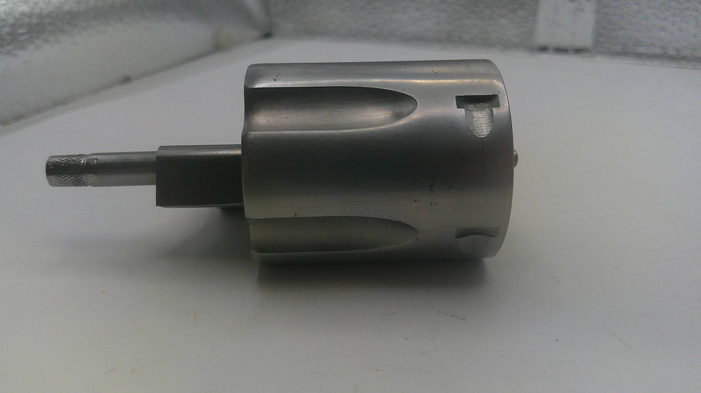 Metal cylindrical component on a white surface with a blurred background