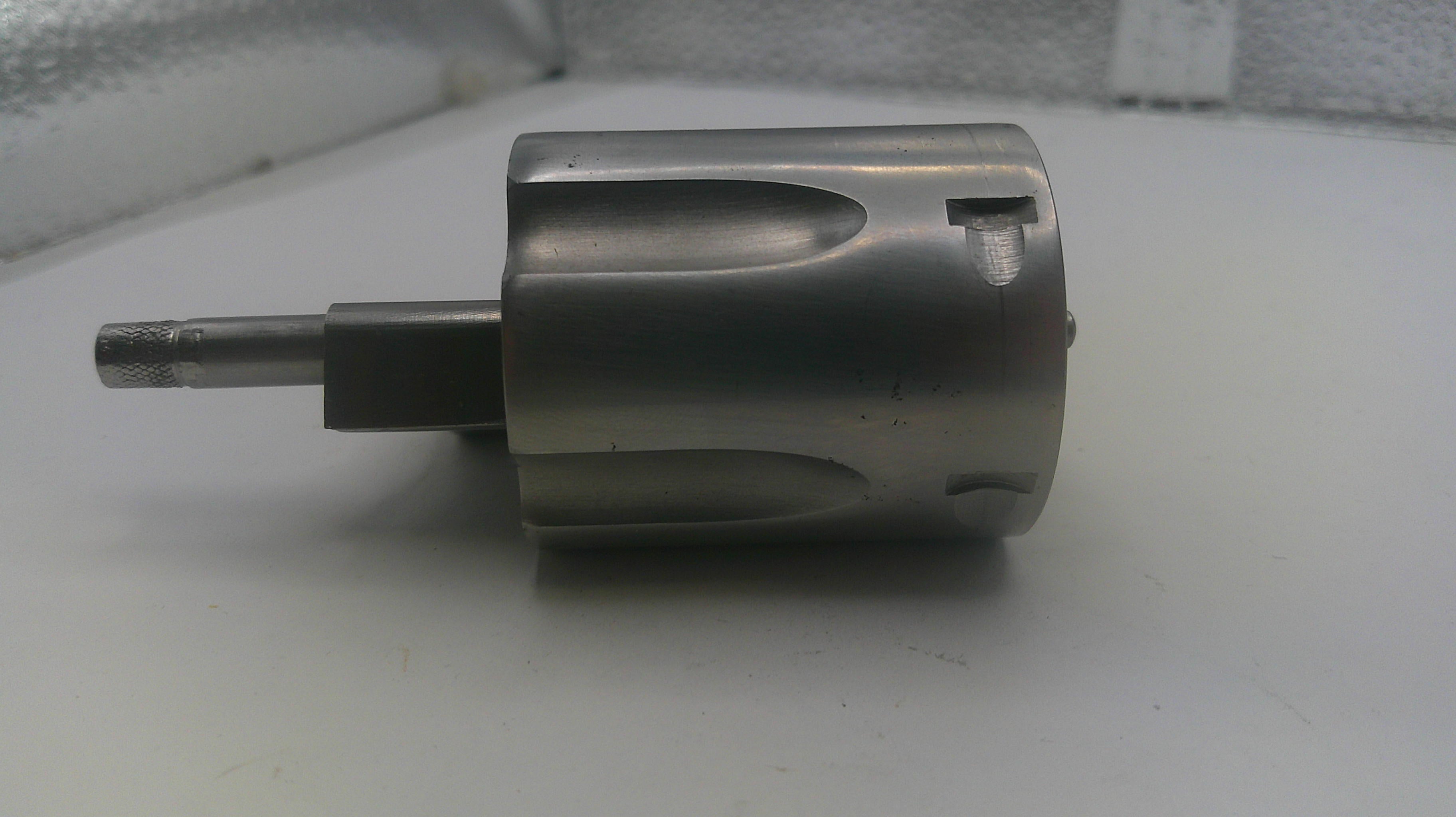 Metal cylindrical component on a white surface with a blurred background