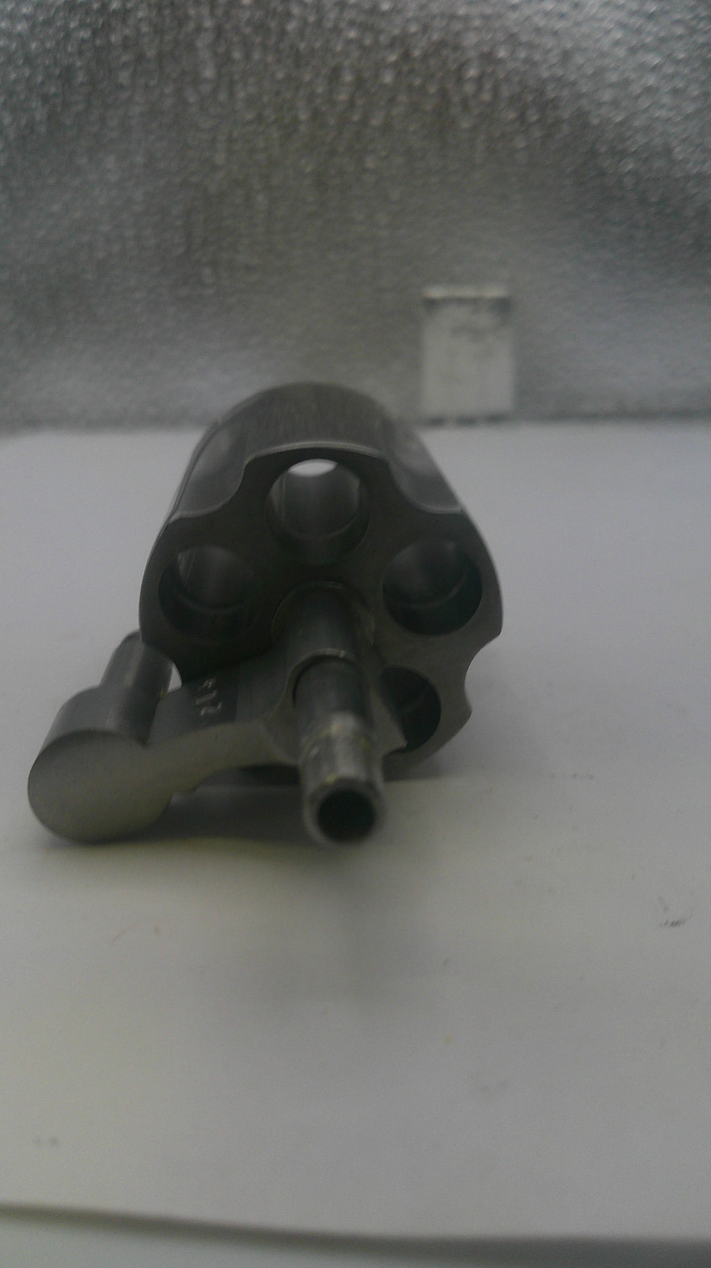 Black gun-like object on a textured gray surface