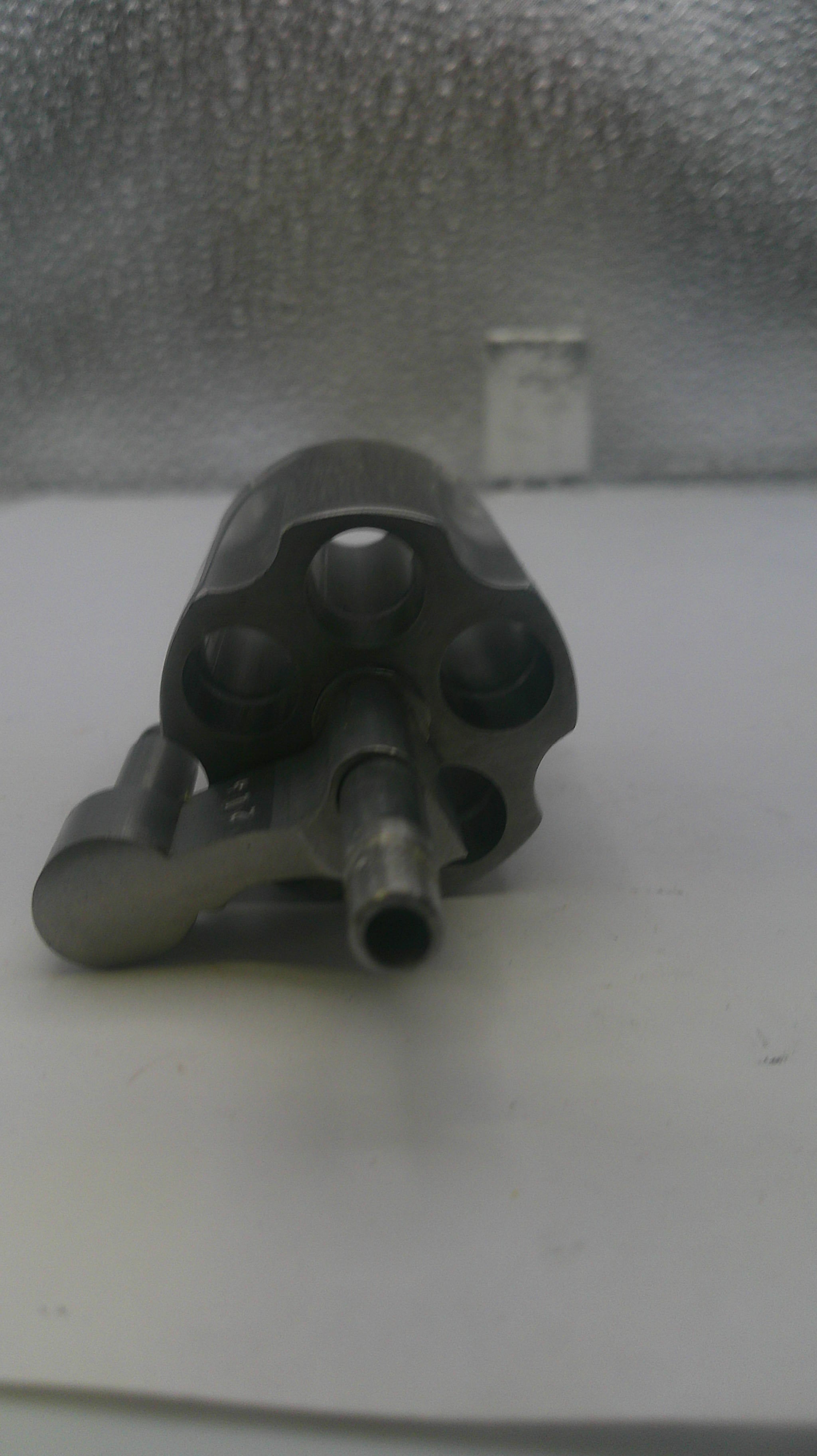Black gun-like object on a textured gray surface