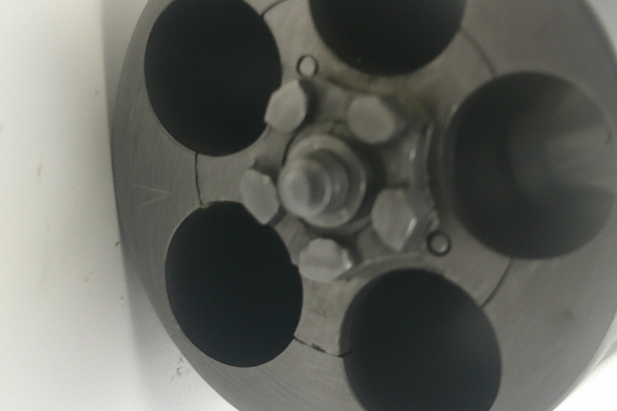 Close-up of a metallic object with circular components on a white background