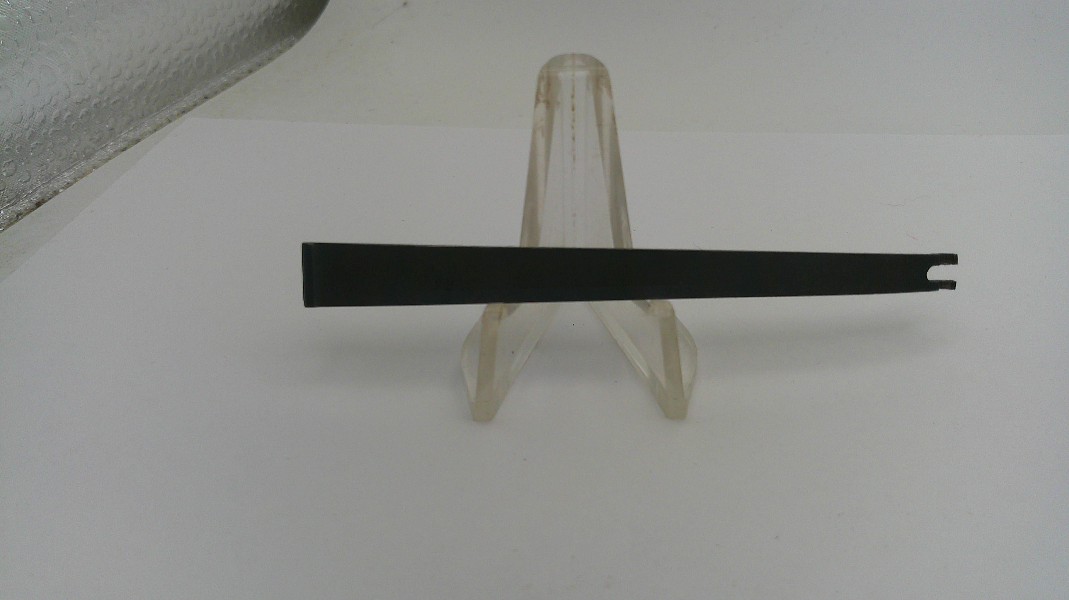 Black metal bar on a clear plastic stand against a white background