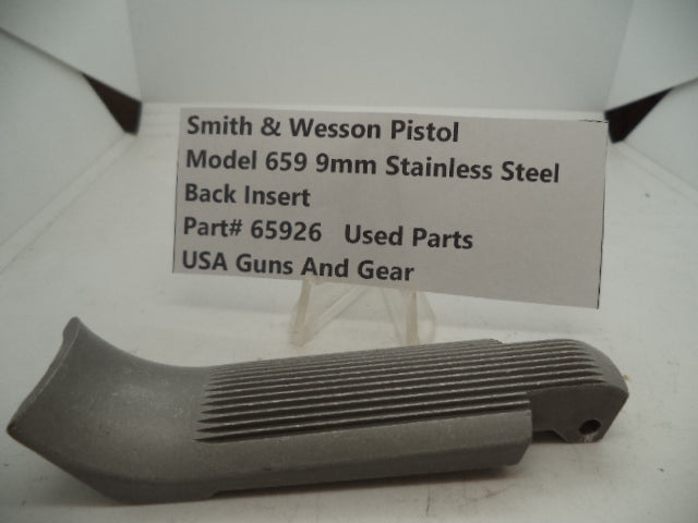 A stainless steel back insert part labeled as 'Smith & Wesson Pistol Model 659 Stainless Steel' with the text 'BACK INSERT' and 'PART 65926' displayed on a label.