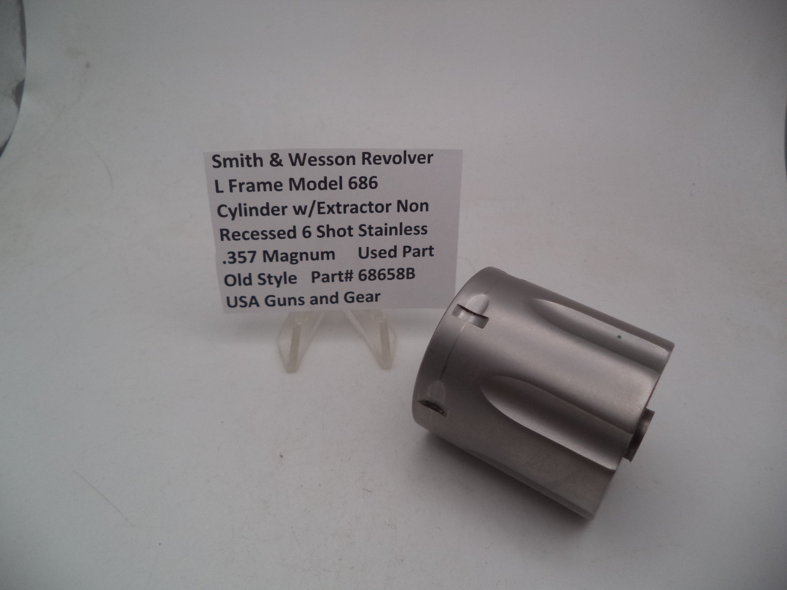 A Smith & Wesson revolver L Frame Model 686 cylinder with extractor, non-recessed .357 Magnum used part, displayed on a white background.