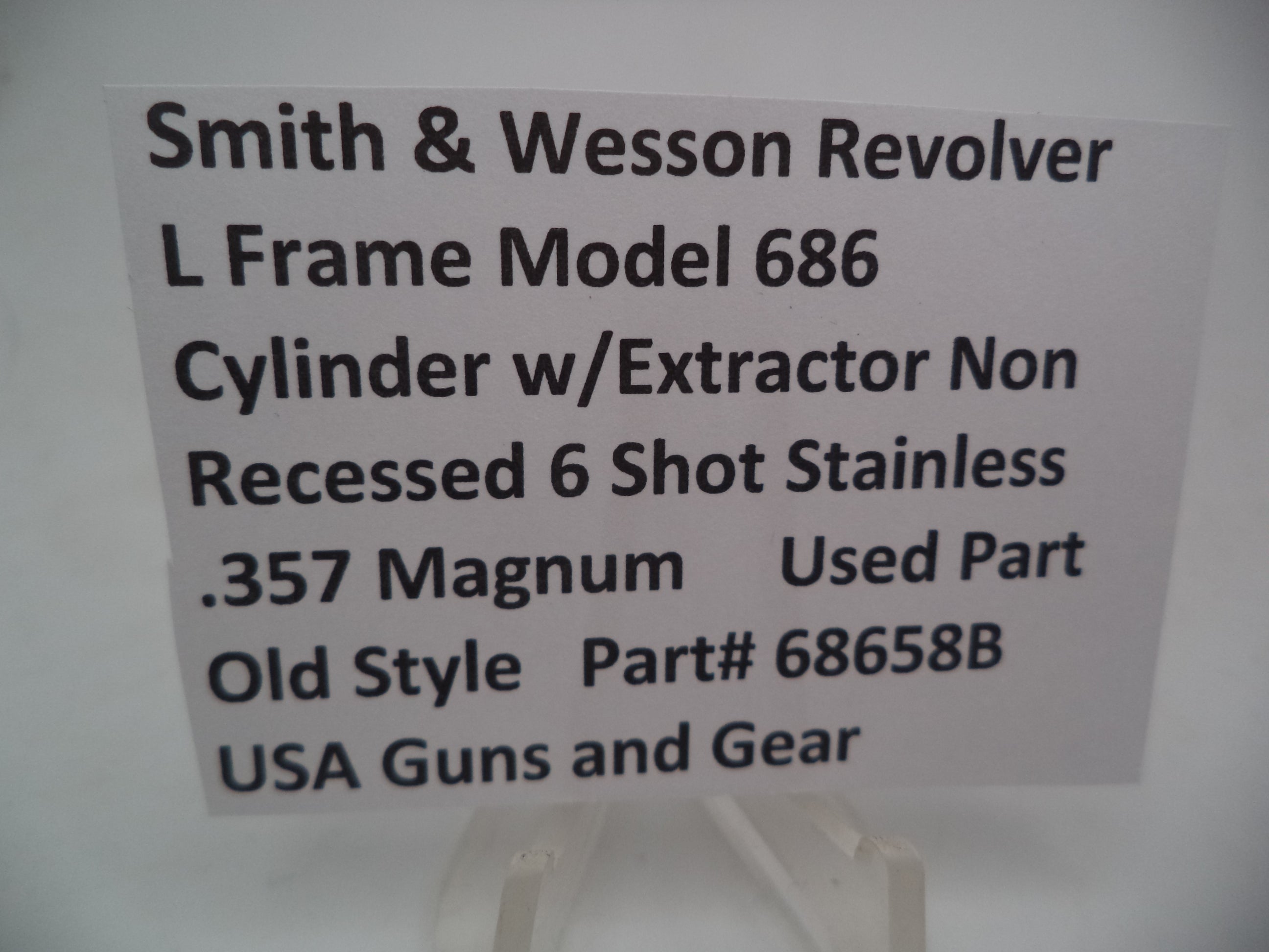A Smith & Wesson revolver L Frame Model 686 cylinder with extractor, non-recessed .357 Magnum used part, displayed on a white background.