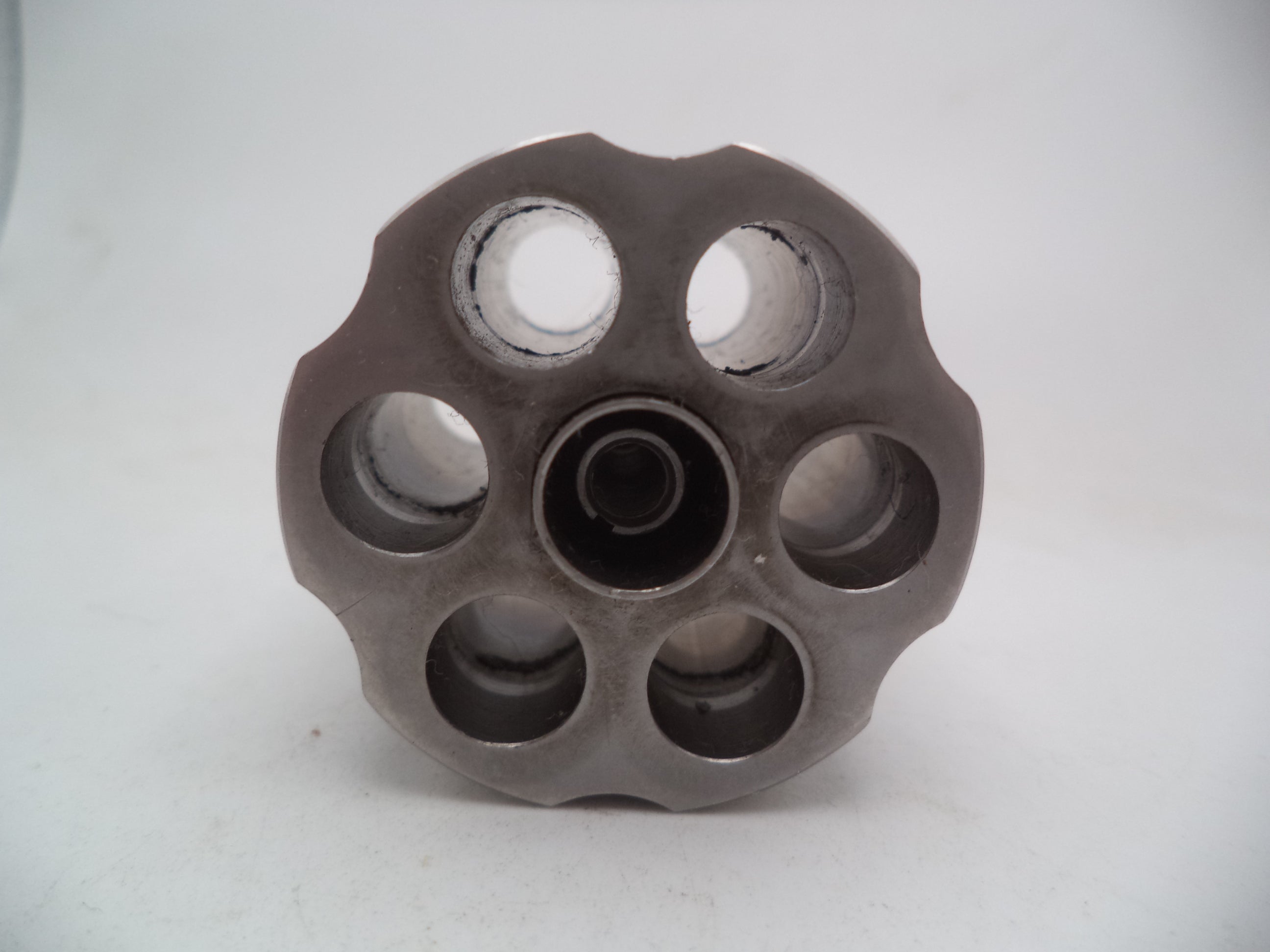 A Smith & Wesson revolver L Frame Model 686 cylinder with extractor, non-recessed .357 Magnum used part, displayed on a white background.