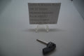 Smith & Wesson SW22 Victory Hammer Assembly displayed on a tripod stand with a sign indicating the part number and manufacturer, accompanied by a key for size comparison.