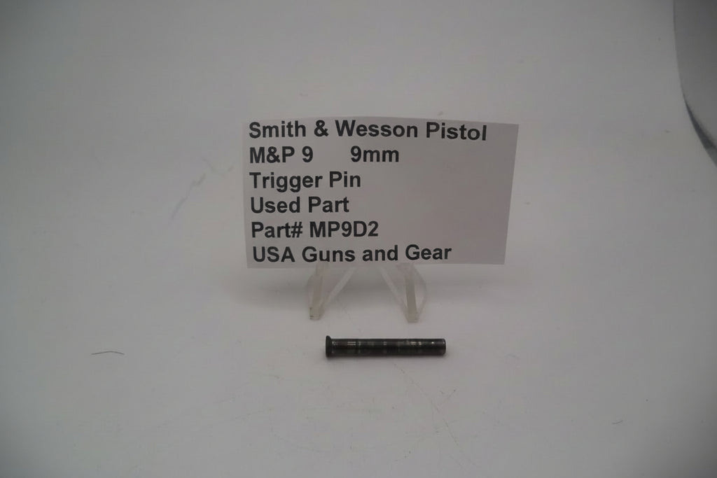 A photo showing a Smith & Wesson M&P9 9mm trigger pin used replacement part, displayed on a stand with product information sign.