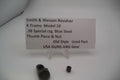 Smith & Wesson revolver parts with a label on a white background