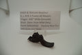 Black gun trigger on a white background with a label detailing product information.